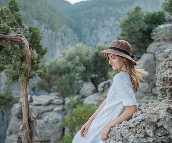 Person meditating in a calm natural environment with soft lighting.